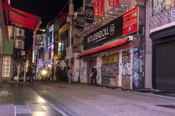 Tourists walk through the narrow alley of Takeshita-dori, Takeshita Street, with souvenir shops and restaurants in the Harajuku neighbourhood at night, tourist attraction, sight, Shibuya district, Tokyo, Japan