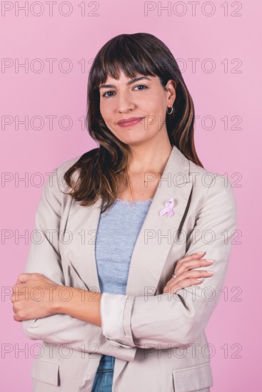 Positive woman with hands behind head and pink ribbon symbolizing breast cancer awareness