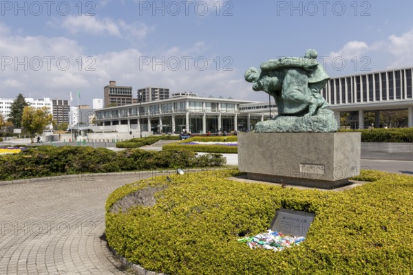 Statue of mother and children in the storm, bronze statue by the artist Shin Hongo in front of the Hiroshima Peace Museum, landmark, UNESCO World Heritage Site, peace memorial and memorial to the victims of the atomic bombing of Hiroshima in the Peace Park, Naka Ward, Hiroshima, Japan