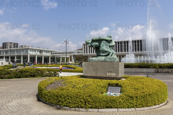 Statue of Mother and Children in the Storm, bronze statue by artist Shin Hongo and Fountain of Prayer in front of the Hiroshima Peace Museum, landmark, UNESCO World Heritage Site, peace memorial and memorial to the victims of the atomic bombing of Hiroshima in the Peace Park, Naka Ward, Hiroshima, Japan