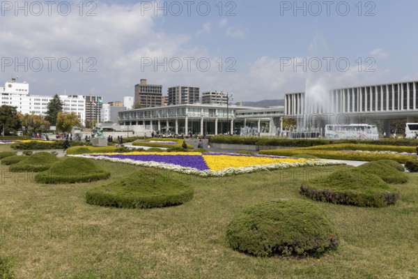 Colourful flower beds and fountains in front of the Hiroshima Peace Museum, tourist attraction, UNESCO World Heritage Site, peace memorial and memorial to the victims of the atomic bombing of Hiroshima in the Peace Park, Naka Ward, Hiroshima, Japan