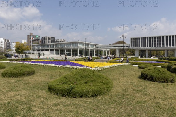 Colourful flower beds in front of the Hiroshima Peace Museum, tourist attraction, UNESCO World Heritage Site, peace memorial and memorial to the victims of the atomic bombing of Hiroshima in the Peace Park, Naka Ward, Hiroshima, Japan