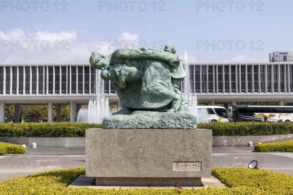 Statue of mother and children in the storm, bronze statue by the artist Shin Hongo in front of the Hiroshima Peace Museum, landmark, UNESCO World Heritage Site, peace memorial and memorial to the victims of the atomic bombing of Hiroshima in the Peace Park, Naka Ward, Hiroshima, Japan
