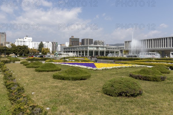 Colourful flower beds and fountains in front of the Hiroshima Peace Museum, tourist attraction, UNESCO World Heritage Site, peace memorial and memorial to the victims of the atomic bombing of Hiroshima in the Peace Park, Naka Ward, Hiroshima, Japan