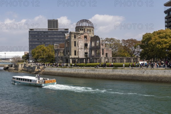 Excursion boat and atomic bomb dome, Atomic Bomb Dome, ruins of the former Chamber of Commerce and Industry building, tourist attraction, UNESCO World Heritage Site, peace memorial and memorial to the victims of the atomic bombing of Hiroshima in the Peace Park on the Otagawa River, Naka Ward, Hiroshima, Japan