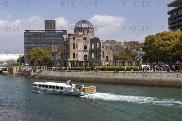 Excursion boat and atomic bomb dome, Atomic Bomb Dome, ruins of the former Chamber of Commerce and Industry building, tourist attraction, UNESCO World Heritage Site, peace memorial and memorial to the victims of the atomic bombing of Hiroshima in the Peace Park on the Otagawa River, Naka Ward, Hiroshima, Japan