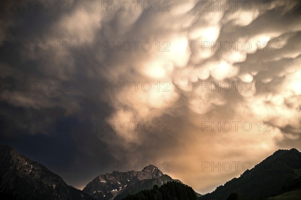 Dramatic cloud formations over a mountain massif in the evening light. Kleinwalsertal Vorarlberg Austria