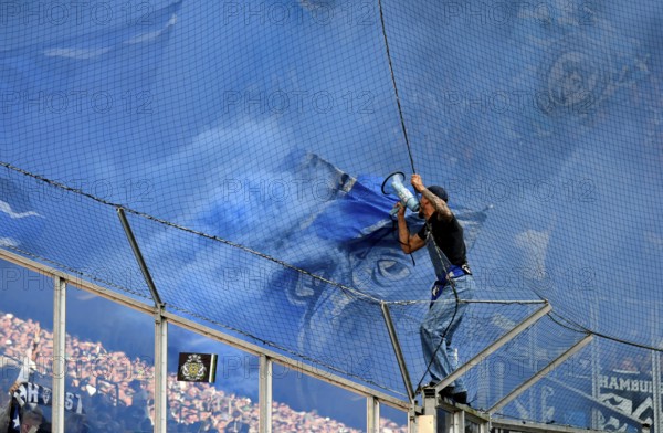 Borussia Park Mönchengladbach, 24.8.2025 Football: Bundesliga Season 2025/26 1st Matchday, Borussia Mönchengladbach (BMG, white) vs Hamburger Sportverein (HSV, blue) _ Pre-singer and Ultra HSV Fans in the guest fan block in blue smoke _ DFL REGULATIONS PROHIBIT ANY USE OF PHOTOGRAPHS AS IMAGE SEQUENCES AND/OR QUASI-VIDEO