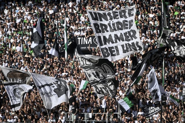 Borussia Park Mönchengladbach, 24.8.2025 Football: Bundesliga Season 2025/26 1st Matchday, Borussia Mönchengladbach (BMG, white) vs Hamburger Sportverein (HSV, blue) _ Fans on the North Curve with flags, slogan Unsere Brüder immer bei uns _ DFL REGULATIONS PROHIBIT ANY USE OF PHOTOGRAPHS AS IMAGE SEQUENCES AND/OR QUASI-VIDEO