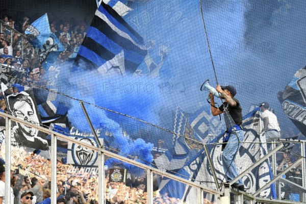 Borussia Park Mönchengladbach, 24.8.2025 Football: Bundesliga Season 2025/26 1st Matchday, Borussia Mönchengladbach (BMG, white) vs Hamburger Sportverein (HSV, blue) _ Pre-singer and Ultra HSV Fans in the guest fan block in blue smoke _ DFL REGULATIONS PROHIBIT ANY USE OF PHOTOGRAPHS AS IMAGE SEQUENCES AND/OR QUASI-VIDEO