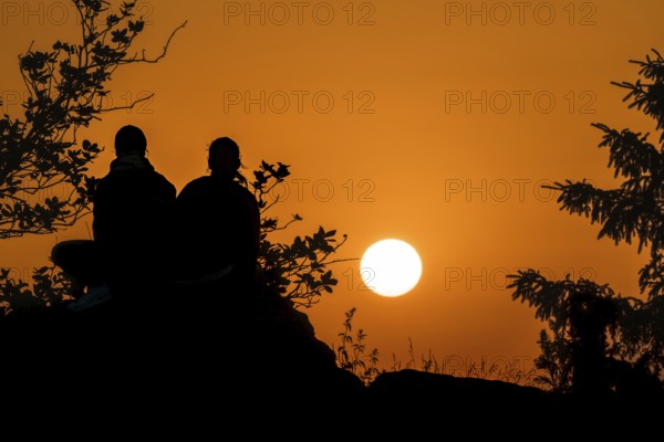Silhouettes in front of the setting sun. Großer Feldberg in the Taunus, Hesse, Germany