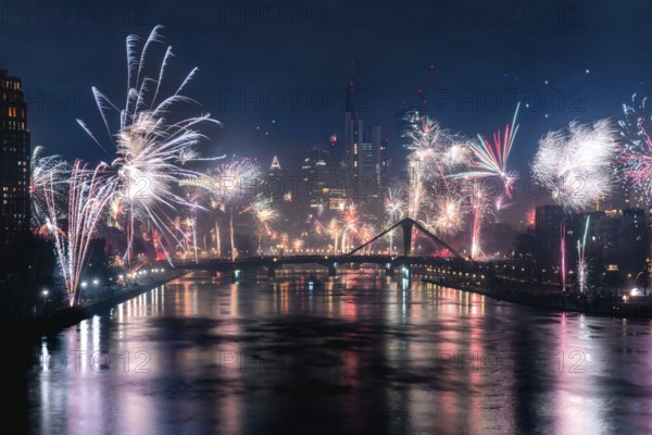 New Year's Eve fireworks illuminate the night skyline on the Main. Frankfurt city centre, Hesse, Germany