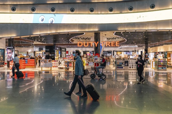 Travellers walk past the duty free shop. Istanbul Airport, Arnavutköy, Istanbul, Turkey