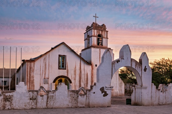 Church at sunset, warm colour palette with illuminated sky and cross tower, The church of San Pedro de Atacama in Chile