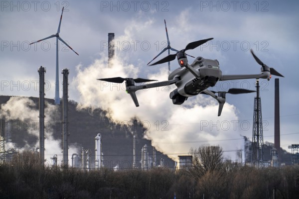 Symbolic image, photomontage, reconnaissance, spying with drones in industrial plants, critical infrastructure, drone flies towards an industrial complex, chemical plant, spying by camera drones