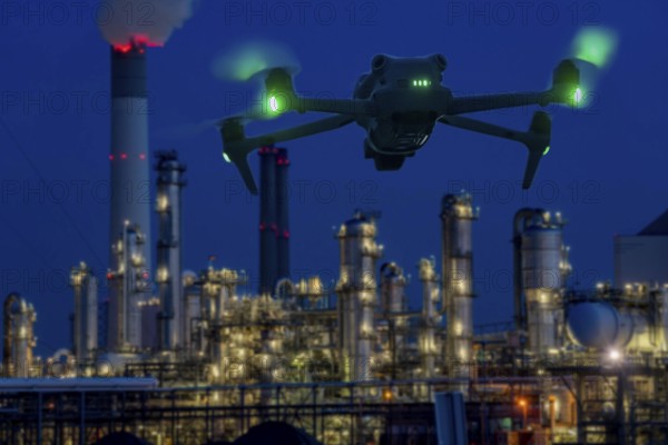 Symbolic image, photomontage, reconnaissance, spying with drones in industrial plants, critical infrastructure, drone flies towards an industrial complex, chemical plant, spying by camera drones