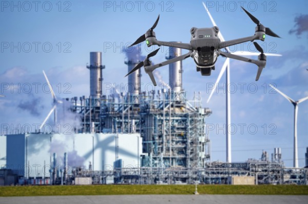 Symbolic image, photomontage, reconnaissance, spying with drones in industrial plants, critical infrastructure, drone flies towards an industrial complex, power plant, gas-fired power plant, spying by camera drones