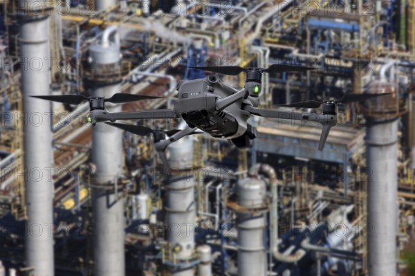 Symbolic image, photomontage, reconnaissance, spying with drones in industrial plants, critical infrastructure, drone flies towards an industrial complex, chemical plant, spying by camera drones