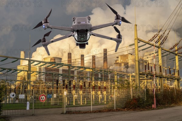 Symbolic image, photomontage, reconnaissance, spying with drones in industrial plants, critical infrastructure, drone flies towards an industrial complex, power plant, substation, spying by camera drones