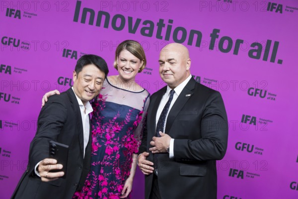 Sara Warneke (Managing Director of gfu Consumer & Home Electronics GmbH, centre) and Leif-Erik Lindner (Managing Director of IFA Management GmbH, right) have their photo taken in front of the opening gala of the IFA Funkausstellung in the CityCube, Berlin, 4 September 2025