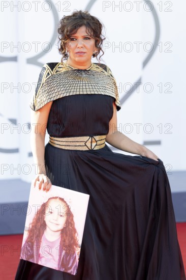 Venice, Italy - 3 September 2025: Kaouther Ben Hania with a portrait of five-year-old Palestinian girl Hind Rajab, who was killed by the Israeli army in the Gaza Strip in January 2024, during the red carpet of - The Voice Of Hind Rajab - during the 82nd Venice International Film Festival
