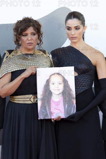 Venice, Italy - 3 September 2025: Kaouther Ben Hania, Saja Kilani with a portrait of the five-year-old Palestinian girl Hind Rajab, who was killed by the Israeli army in the Gaza Strip in January 2024, during the red carpet of - The Voice Of Hind Rajab - during the 82nd Venice International Film Festival