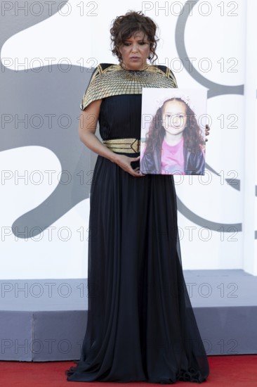 Venice, Italy - 3 September 2025: Kaouther Ben Hania with a portrait of five-year-old Palestinian girl Hind Rajab, who was killed by the Israeli army in the Gaza Strip in January 2024, during the red carpet of - The Voice Of Hind Rajab - during the 82nd Venice International Film Festival