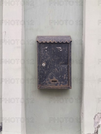 Old metal mailbox hanging on the wall of the house, copy space