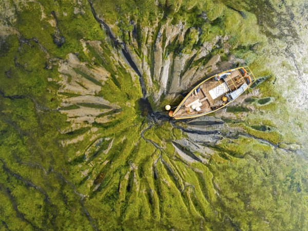 Top Down over boat and mud from drone, Paulsgrove Lake, Portchester Castle, Portchester, Fareham, Hampshire, England, United Kingdom