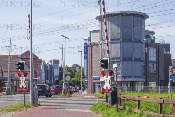 Gated railway crossing with houses, Leer, East Frisia, Lower Saxony, Germany