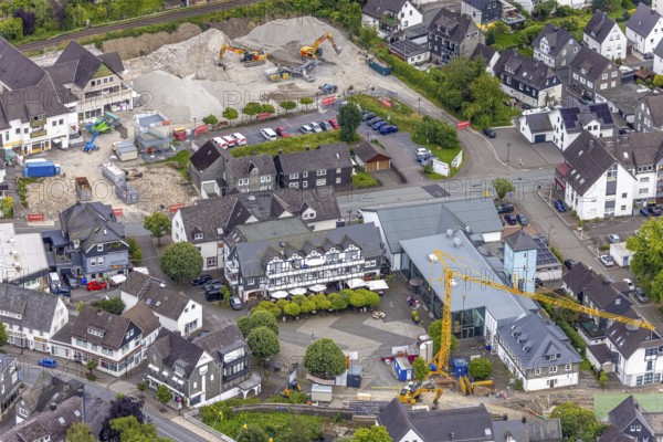 Aerial view, community centre and market square with shops, restaurant and sunshades and trees, above construction site car park demolition, construction site at community centre, Bad Berleburg, Wittgensteiner Land, North Rhine-Westphalia, Germany, demolition, architecture, construction work, construction site, trees, community centre, German, village, retail, open air, gastronomy, building, shops, home, infrastructure, landscape, aerial perspective, market square, car park, square, restaurant, summer, sunshades, town, town planning, town centre, urban, daytime, historical, regional