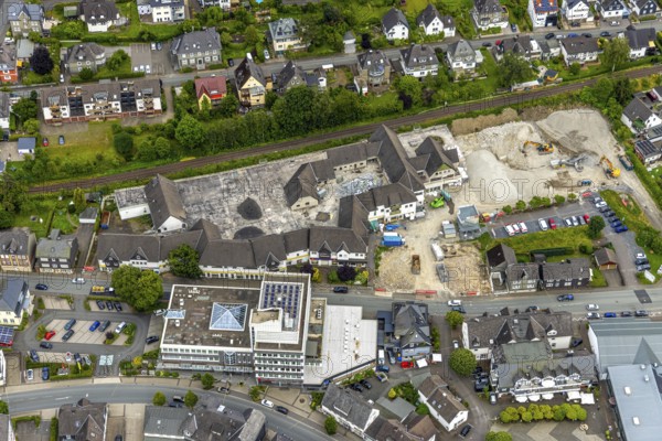 Aerial view, car park demolition and demolition of the former Eins-A complex on Schulstrasse, commercial building on Schulstrasse, Bad Berleburg, Wittgensteiner Land, North Rhine-Westphalia, Germany, demolition, demolition, demolition work, labour, architecture, construction work, construction site, Eins-A complex, progress, building, site, commercial building, trade, helicopter perspective, infrastructure, infrastructure project, construction, aerial view, machinery, modernisation, car park, region, renovation, Schulstrasse, summer, town, urban development, street view, structure, daylight, urban, change, tools, reconstruction, destruction