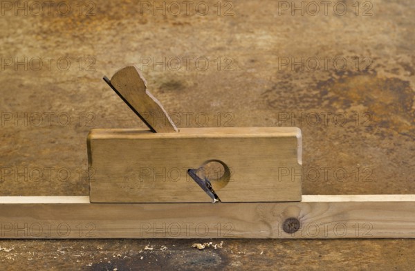 Old planer on wooden plank