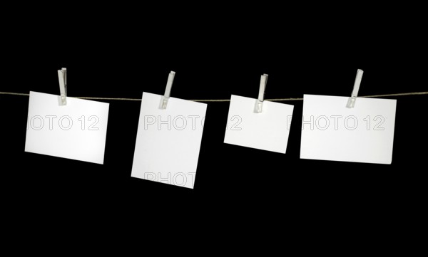 Clothesline with some white labels fixed with clothes pins in black back