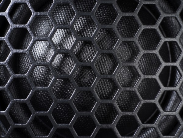Full frame black grid of a speaker detail in dark back