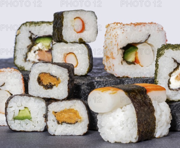 Various sushi dishes on dark grey stone surface