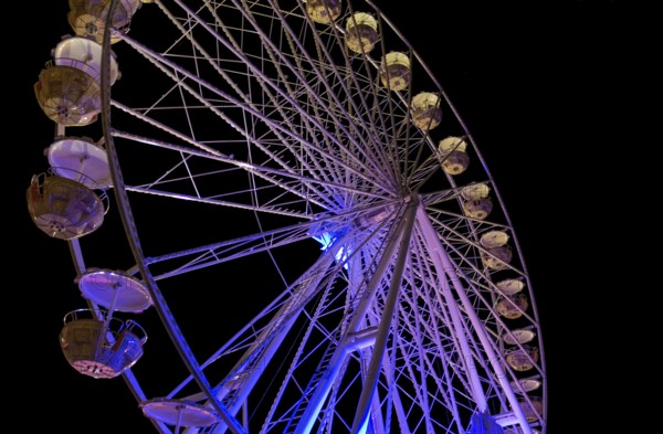 Colorful illuminated ferris wheel detail at night