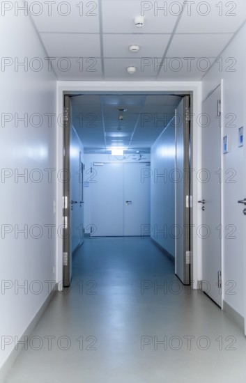 Blue illuminated corridor including some doors