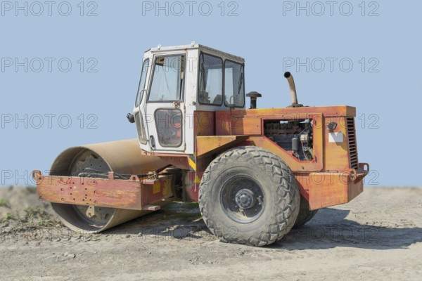 A roller-compactor in sunny illuminated building lot ambiance