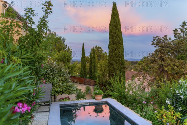 Idyllic scenery including a small swimming pool seen in Beaumes-de-Venise, a commune in the Vaucluse department in the Provence region in southeastern France at evening time