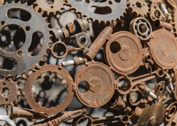 Closeup shot of a rusty sculpture welded of various metal pieces in sunny ambiance