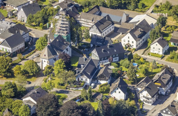 Aerial view, Heinsberg town centre and construction site and renovation work on the steeple of the Catholic parish church of St. Katharina, Heinsberg, Kirchhundem, Sauerland, North Rhine-Westphalia, Germany, construction work, construction area, construction site, scaffolding, building plots, construction project, construction site, DE, Europe, aerial view, aerial photography, aerial photography, new building, overview, bird's-eye view, overview