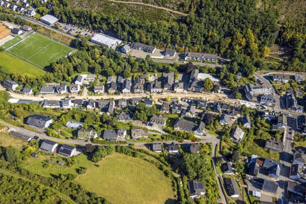 Aerial view, Hundemstraße road construction work with closure, football stadium sports field FC Kirchhundem 1946 and tennis court TC Rot-Weiß Kirchhundem, residential area, Kirchhundem, Sauerland, North Rhine-Westphalia, Germany, construction work, construction area, building site, building plots, construction measure, construction project, construction site, DE, Europe, football, football field, football stadium, property tax, real estate, aerial view, aerial photography, aerial photography, new construction, sports, sports facility, sports field, tennis, tennis facility, tennis court, tennis courts, tennis club, overview, bird's-eye view, residential complex, housing and living, quality of living, residential neighbourhood, housing estate, residential area, birds-eyes view, overview