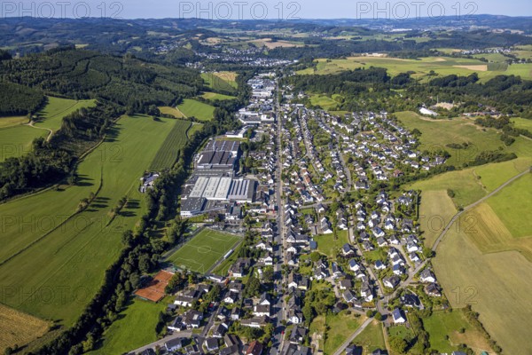 Aerial view, residential area local view at the Bielefelder Straße with commercial area, football stadium sports ground SSV Elspe 1911 e.V. and tennis court TC Elspe, Elspe, Lennestadt, Sauerland, North Rhine-Westphalia, Germany, DE, Europe, football, football field, football stadium, commercial enterprise, commercial area, commercial property, commercial site, commercial use, property tax, real estate, industrial area, industrial site, Kirchhundem, aerial view, aerial photography, aerial photography, sports facility, sports field, tennis, tennis facility, tennis court, tennis courts, tennis club, overview, bird's-eye view, residential area, residential area and living, residential quality, residential neighbourhood, residential estate, residential district, birds-eyes view, overview