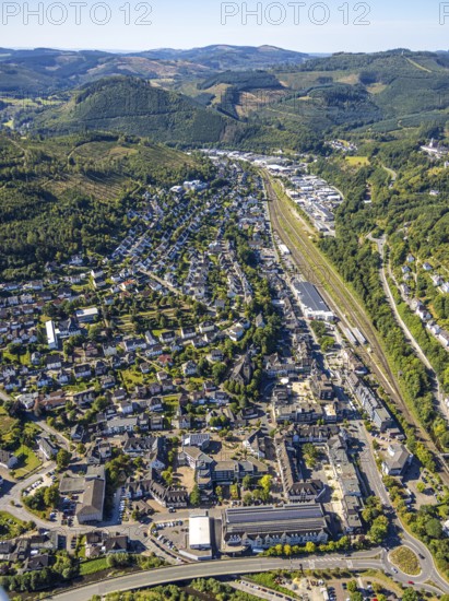 Aerial view, residential area view of Altenhundem with town hall Thomas-Morus-Platz, police station Bürgermeister-Beckmann-Platz, catholic parish church St. Agatha and market place, railway station Lennestadt-Altenhundem, HIT supermarket and Aldi supermarket, hilly landscape distant view and forest area with forest damage, Altenhundem, Lennestadt, Sauerland, North Rhine-Westphalia, Germany, place of worship, railway area, railway station, platform, authority, community centre, DE, Deutsche Bahn AG, shopping centre, shopping markets, shopping place, shopping centre, Europe, denomination, church, parish, church community, Kirchhundem, aerial view, aerial photography, aerial photograph, aerial photography, local supply centre, police, police station, police station, town hall, religion, religious site, shopping centre, state authority, state power, city administration, overview, bird's-eye view, overview