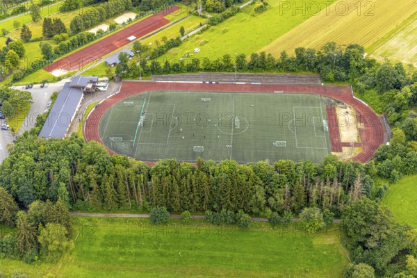 Aerial view, football stadium athletics stadium Auf dem Stöppel, sports field Bad Berleburg, youth players on the field, Bad Berleburg, Wittgensteiner Land, North Rhine-Westphalia, Germany, activity, architecture, athletes, Auf dem Stöppel, outdoor shot, leisure, football, football stadium, community, youth players, youth sport, landscape, athletics, athletics stadium, aerial view, grass, region, game, pitch, sport, sports facility, sports field, sports event, town, team, training, stands, surroundings, competition, competition venue
