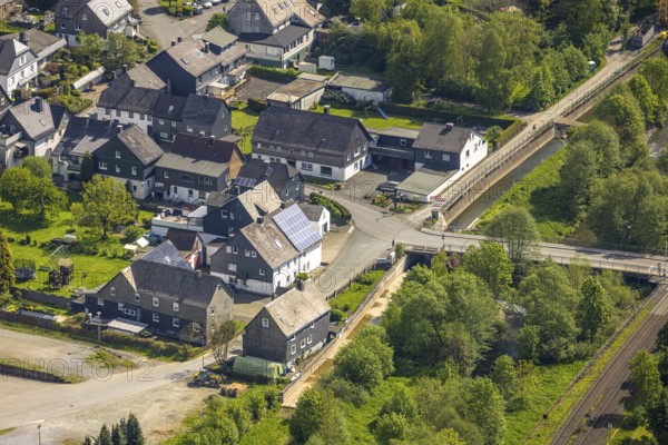 Aerial view, residential area Mühlenstraße corner Kanalstraße, railway line level crossing and Ruhr bridge Kanalstraße, green river Ruhr, behind the weir Velmede, Velmede, Bestwig, Sauerland, North Rhine-Westphalia, Germany, residential area, Mühlenstraße, Kanalstraße, railway line, railway crossing, Ruhr bridge, green river, Ruhr, weir, river landscape, infrastructure, bridge, railway, traffic routes, settlement, houses, streets, water, nature, aerial view, urban planning, region, geographical, european, scenic, urban, architecture, environment, riverbank