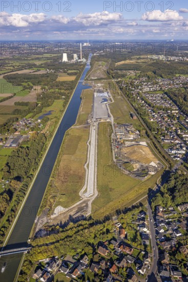 Aerial view, Wasserstadt Aden on the Datteln-Hamm Canal, construction area for planned urban quarter on the site of the former Haus Aden colliery, behind the Bergkamen power station, distant view and blue sky with clouds, Oberaden, Bergkamen, Ruhr area, North Rhine-Westphalia, Germany, architecture, construction work, construction area, construction site, Datteln-Hamm canal, distant view, building, terrain, Haus Aden, sky, industry, industrial area, infrastructure, canal, Bergkamen power station, landscape, perspective, planning, region, urban development, transformation, urban, Wasserstadt Aden, clouds, blue sky, former colliery, planned urban quarter