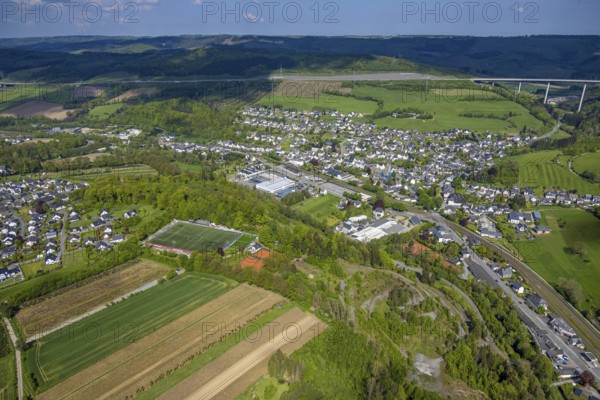 Aerial view, residential area, local view district Nuttlar with motorway A46 valley bridge Nuttlar, mountain range in the background, sports field and tennis courts Ostwig, Nuttlar, Bestwig, Sauerland, North Rhine-Westphalia, Germany, residential area, local view, district, motorway, A46, valley bridge, mountain range, background, sports field, tennis courts, Ostwig, infrastructure, traffic, bridge, mountains, landscape, settlement, environment, district, buildings, houses, football field, recreation, leisure, street, motorway bridge, residential area, greenery, aerial view, panorama, region