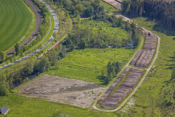 Aerial view, timber wet storage site temporary storage, S-Bahn railway line, road Am Dümel, Ostwig, Bestwig, Sauerland, North Rhine-Westphalia, Germany, timber wet storage, temporary storage, S-Bahn railway line, road, Am Dümel, infrastructure, transport, rail traffic, timber, storage site, industry, logistics, rural, scenic, village, traffic, overview, forest, nature, trade, trees, buildings, tracks